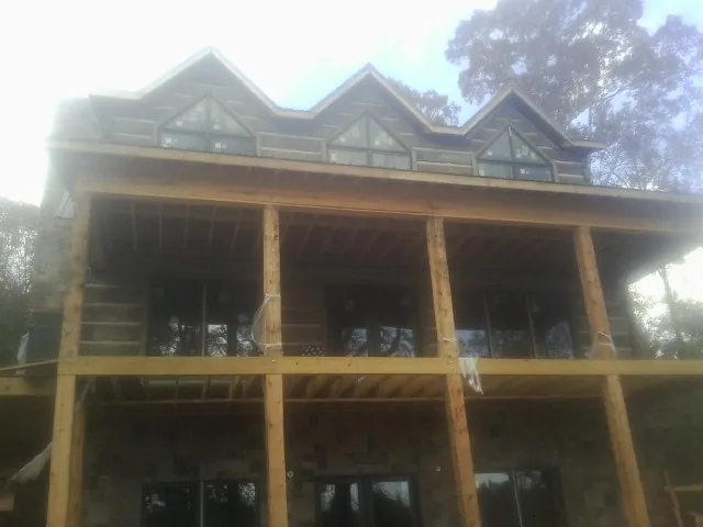 Dormers and porch framing on a large log home under construction — Roof Coating work by our crew in Tehama